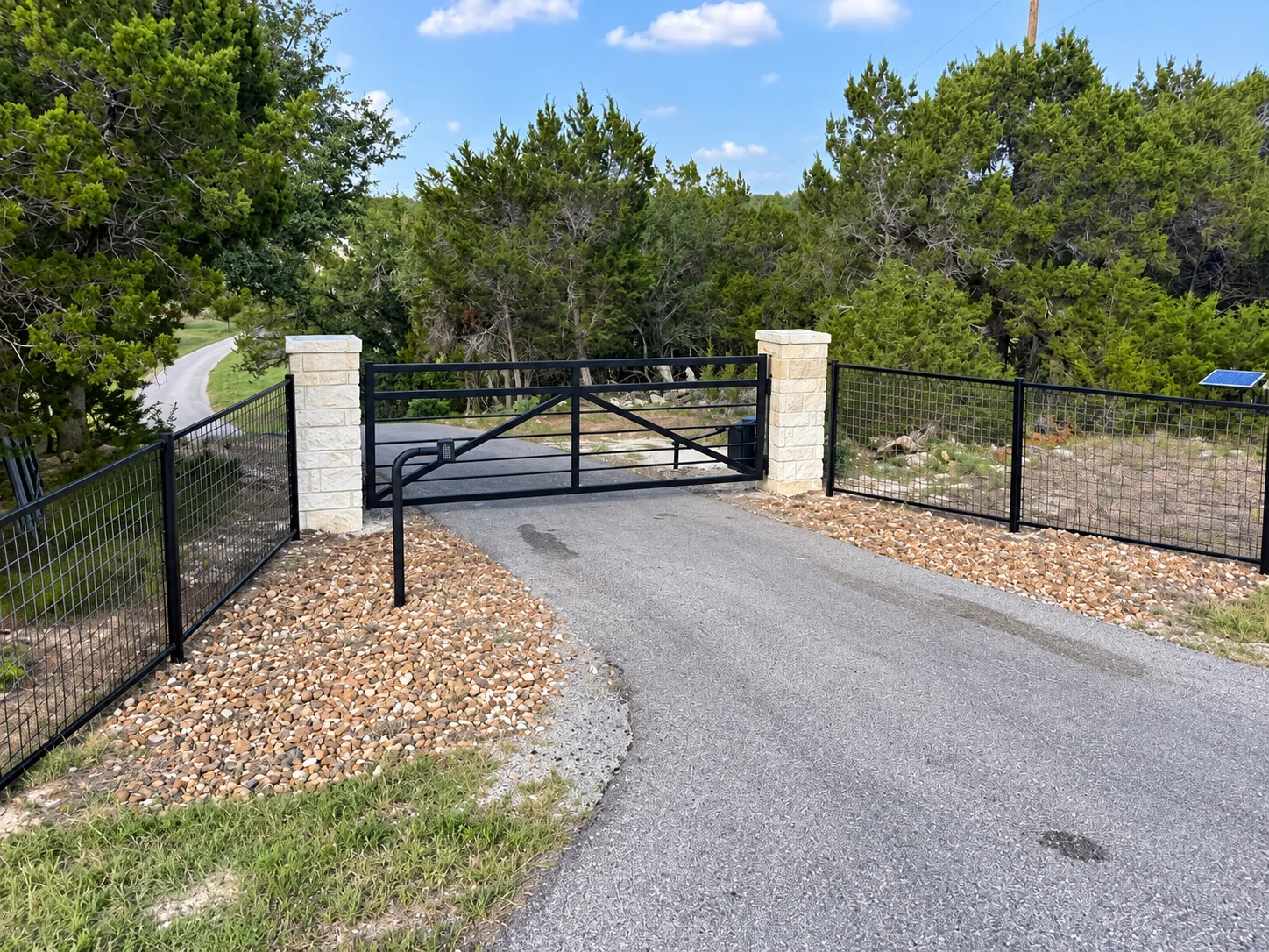 Limestone gate entrance on a wooded driveway